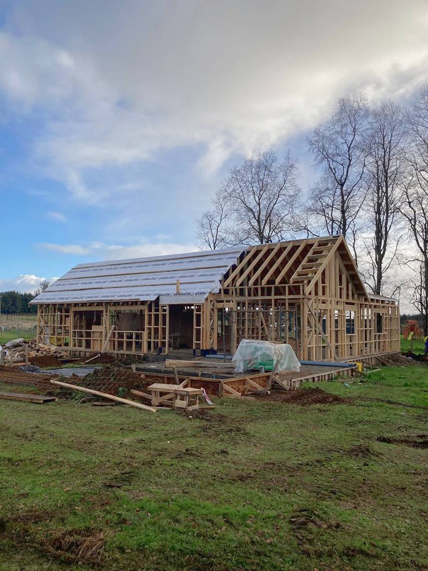 Estructura de madera de una casa en construcción en un campo